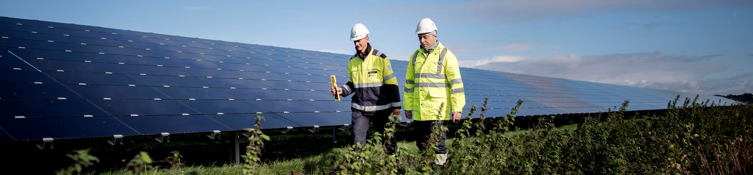 Zwei Mitarbeiter vor Solarpark